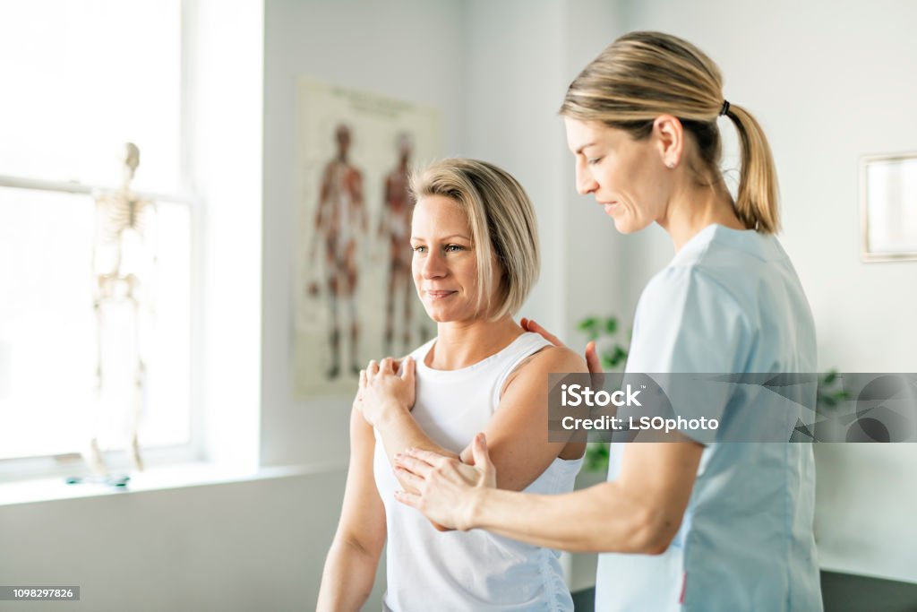 Modern rehabilitation physiotherapy worker with woman client