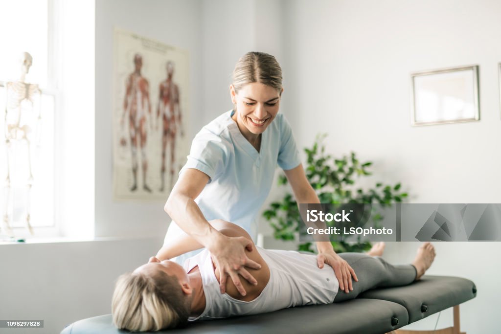 Modern rehabilitation physiotherapy worker with woman client