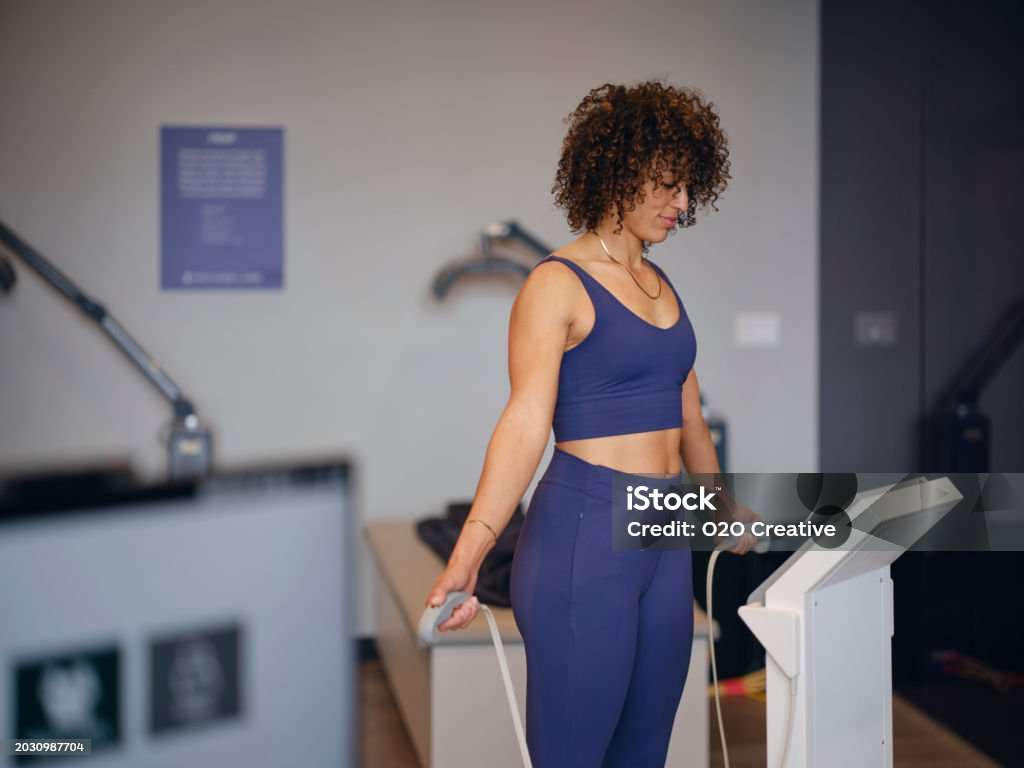 A woman in a biohacking facility, using a body composition analysis machine.